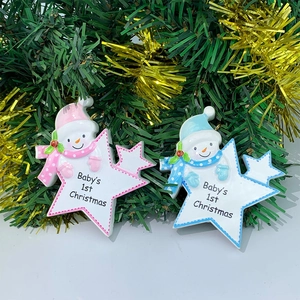 Close-up of resin snowman star ornaments on green pine branches with festive text