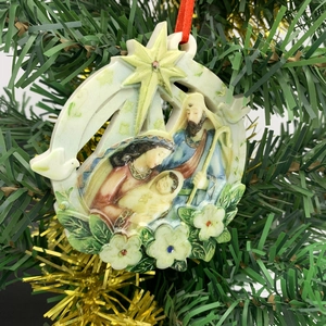 Nativity Scene round resin Christmas ornament with red ribbon on tree branch