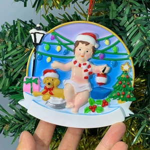 Detail of handcrafted resin Christmas ornament with baby, golden retriever and street lamp