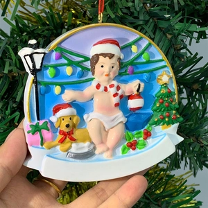 Close-up of resin Christmas tree pendant with child and dog figure held by hand