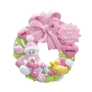 Close-up of pink resin baby's first Christmas ornament with snowman and yellow duck