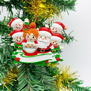 Macro detail of resin Mrs. Claus Christmas ornament with blank banner for DIY names