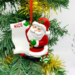 Detail of resin Santa Claus ornament on a Christmas tree holding a Nice list scroll