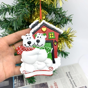 Detail of polar bear resin ornament held by hand against a festive Christmas tree background