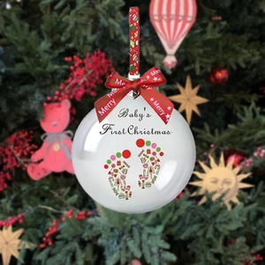 Détail de la boule de Noël Bébé avec empreintes de pieds et ruban rouge festif