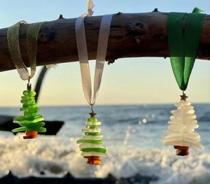 Detailed view of sea glass stack Christmas ornaments hanging on a natural branch