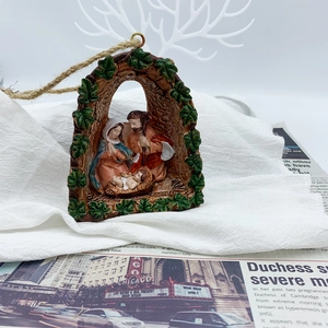 Détail de la crèche en résine avec relief de feuilles vertes et attache en corde rustique