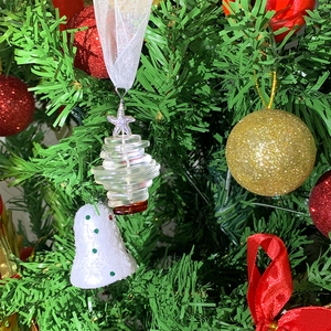 Macro detail of acrylic layered ocean christmas tree ornament on festive pine branches