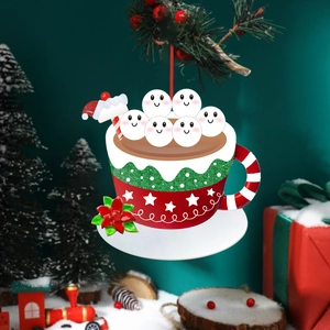 Christmas hot cocoa mug ornament with cute smiling marshmallows hanging on a pine tree