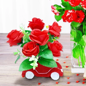 Close-up of artificial red roses in a creative red resin car-shaped flower vase