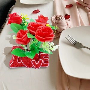 Detail of red artificial rose arrangement on a LOVE letter base for home decor