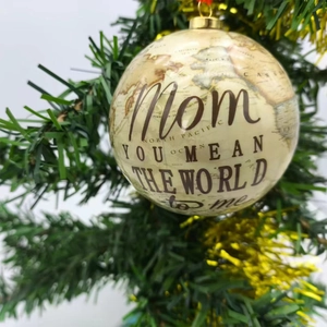 Vintage globe Christmas ornament with Mom quote hanging on a festive tree branch