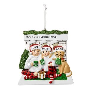 Detail of resin Christmas ornament with couple and golden retriever by a cozy fireplace