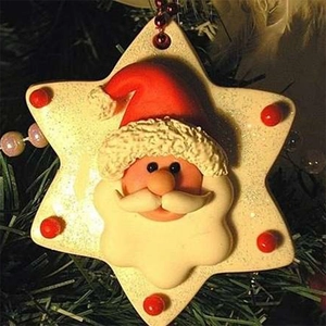 Macro shot of resin snowflake ornament with Santa Claus head on a Christmas tree