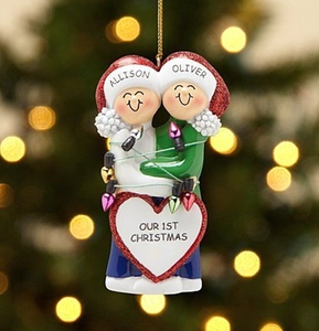 Detail of resin Christmas tree ornament featuring a couple hugging with colorful lights