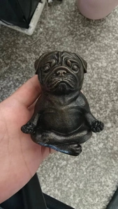 Close-up of a pug dog yoga meditation resin figurine showing the compact handheld size