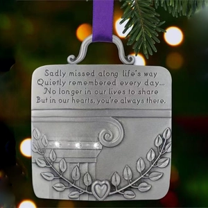 Detailed view of silver angel memorial ornament with purple ribbon and crystal accents