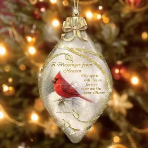 Oval Cardinal Christmas ornament with golden accents on a festive holiday tree branch