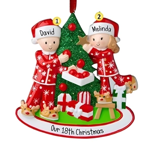 Décoration de Noël personnalisée en résine avec un couple en pyjama et des cadeaux