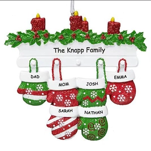 Personalized Christmas resin ornament with 6 red and green snowflake gloves on a fireplace