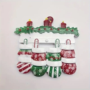 Close-up of resin Christmas fireplace ornament with red candles and four hanging mittens