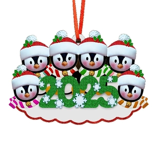 Close-up of 2025 family penguin ornament with six penguins and ribbon for hanging