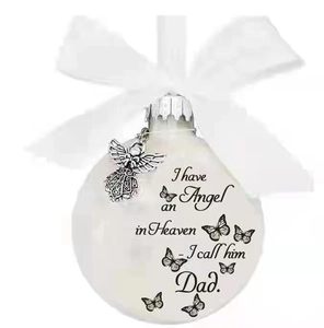 Close-up of white memorial bauble with butterfly print and metal angel pendant