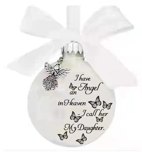 Detail of memorial ball ornament with silver angel charm and daughter tribute text