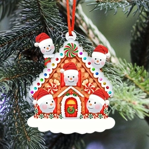 Close-up of gingerbread house Christmas ornament with five snowmen on a pine tree branch
