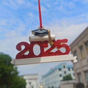 Detail of red glitter 2025 graduation ornament with black mortarboard and diploma