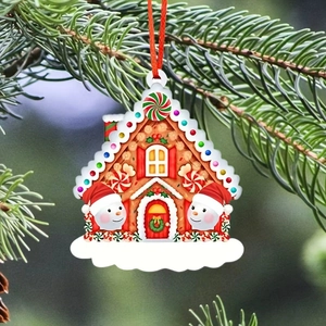 Close-up of gingerbread house Christmas ornament with snowman and hanging red string