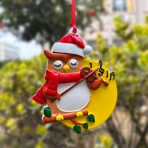 Christmas owl resin ornament playing violin with red hat and scarf on tree branch