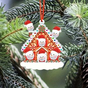 Macro shot of gingerbread house ornament with six snowmen hanging on a Christmas tree