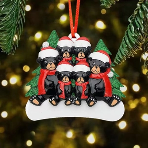 Close-up of black bear family resin Christmas ornament with glitter trees and red scarf