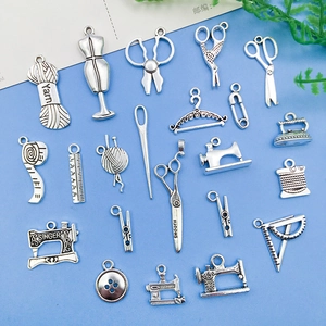 Dettaglio flat lay di ciondoli da cucito argento con forbici e macchina vintage
