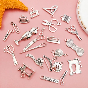 Set ciondoli cucito argento vintage con forbici e icone su sfondo rosa