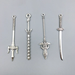 Macro shot of four silver alloy fantasy sword pendants with detailed engraved textures