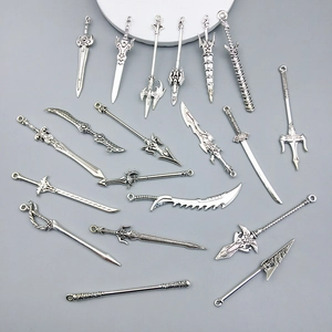 Macro view of assorted vintage silver alloy fantasy sword and weapon charms for DIY jewelry