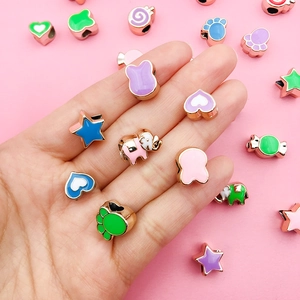 Close-up of colorful enamel charms in heart and star shapes with rose gold base