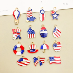 Flat lay of 15 Independence Day alloy pendants with red, white and blue enamel detail