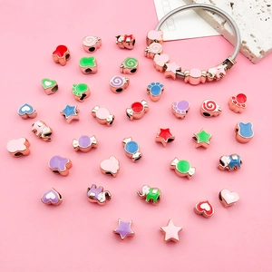 Macro view of rose gold DIY charm beads in star and candy shapes with colorful enamel