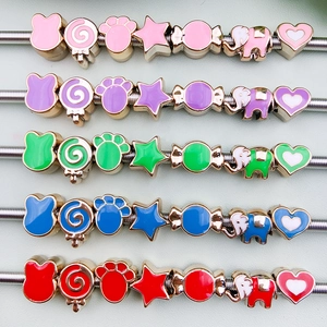 Macro detail of colorful enamel animal and candy charms on a metal spiral display stand