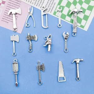 Detailed close-up of antique silver alloy tool charms for DIY crafts and jewelry making