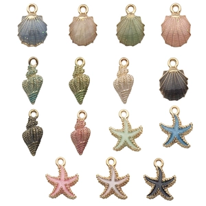 Macro detail of colorful starfish and seashell charms with golden edges for DIY jewelry making