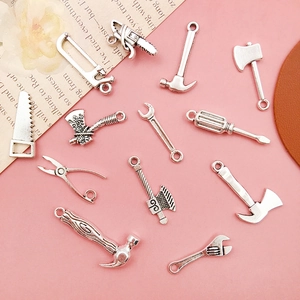 Macro shot of antique silver DIY alloy pendant set featuring miniature craft tool charms