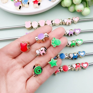 Detail view of colorful enamel animal and star beads for DIY bracelet jewelry making