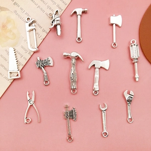 Detailed macro view of vintage silver hardware tool charms for DIY jewelry making