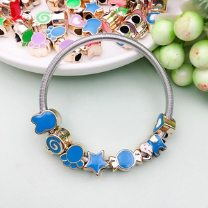 Detailed close-up of blue enamel charms including stars and elephants on a silver DIY bracelet
