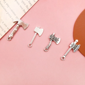 Macro shot of four vintage silver alloy axe charms for DIY jewelry and keychain making