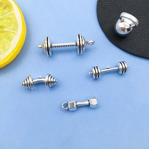 Dettaglio macro di ciondoli a manubrio e kettlebell in argento per gioielli fitness